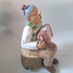 Haitarimies kannolla savityö, puusta tehty istuin.